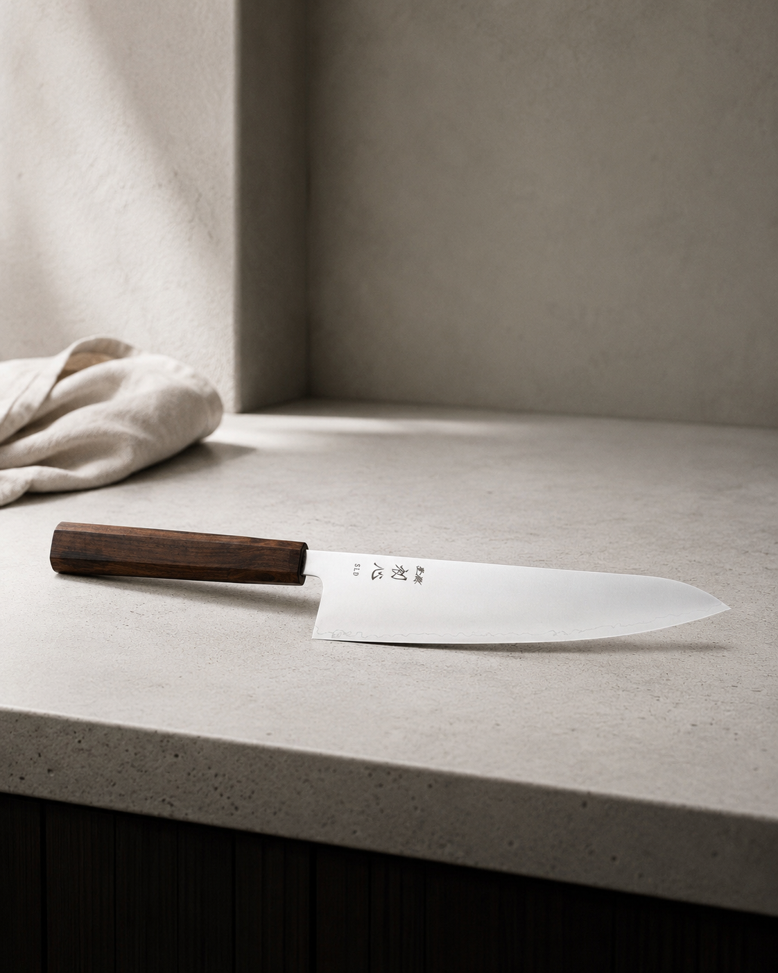 Cuchillo japones Gyuto Hikari SLD Satin sobre encimera de concreto claro