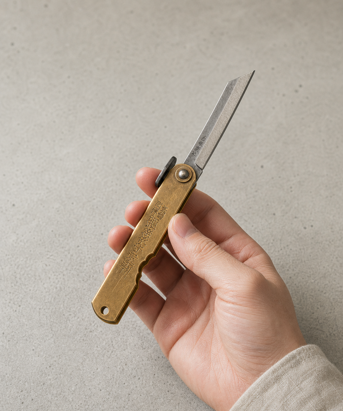 Navaja japonesa Higonokami Aogami Brass en mano para mostrar escala