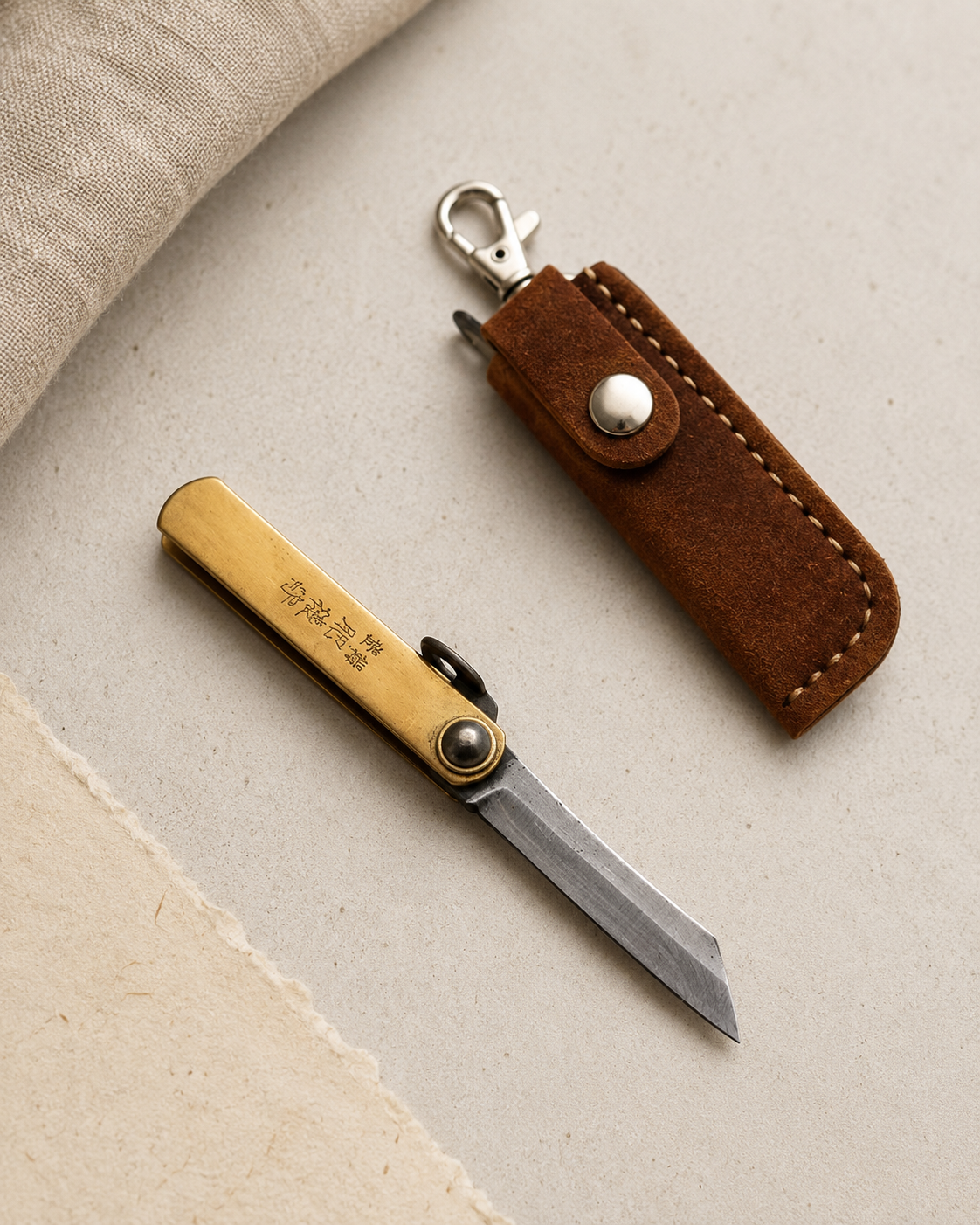 Navaja japonesa Higonokami Mini con funda en escena minimalista