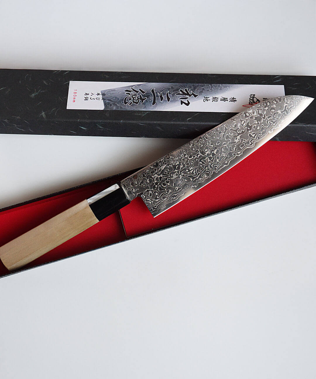 Cuchillo Santoku Damasco preparado sobre fondo claro